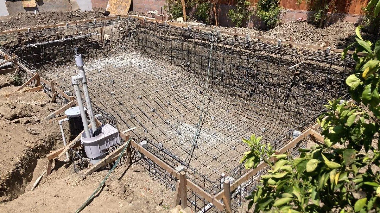 Before: excavated pool pit with steel rebar reinforcement before shotcrete