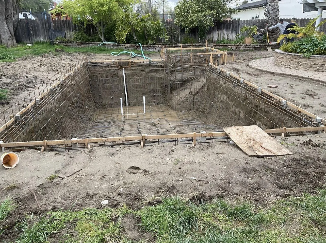 Before: Excavated backyard pool pit with the steel rebar cage in place.