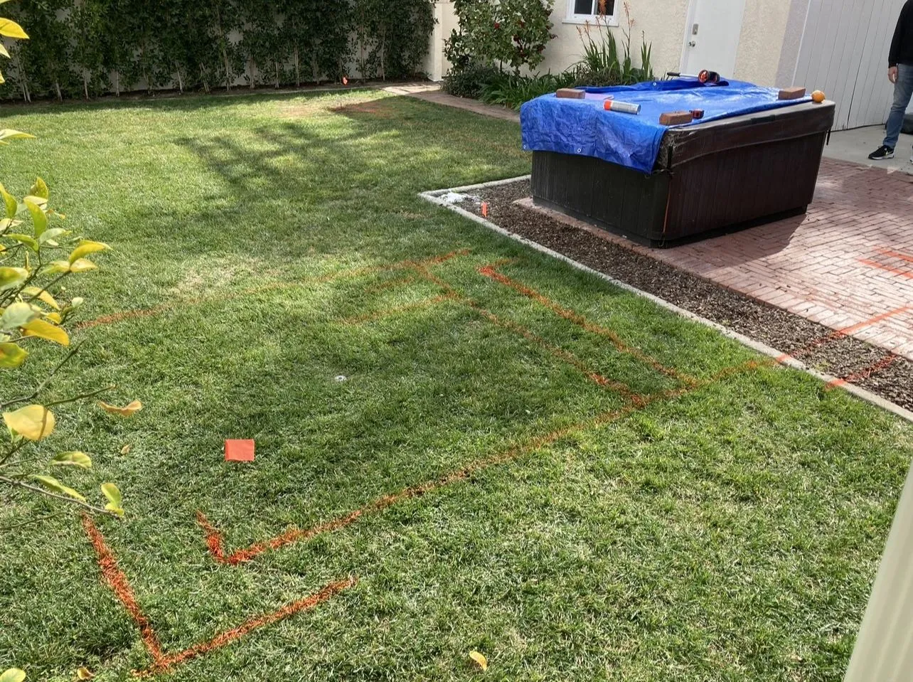 Before: Lawn marked out with spray paint for the new pool footprint, covered spa nearby.