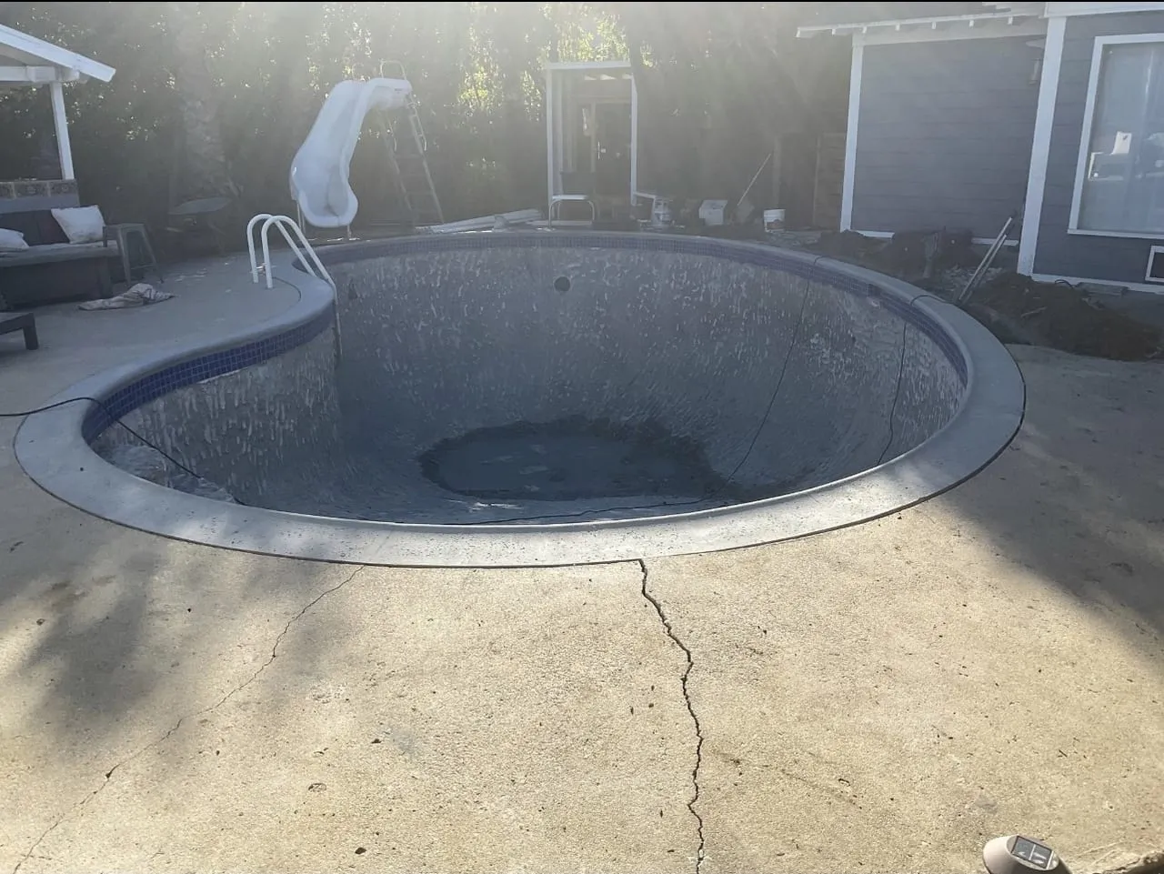 Before: Old drained kidney pool with worn, stained plaster.