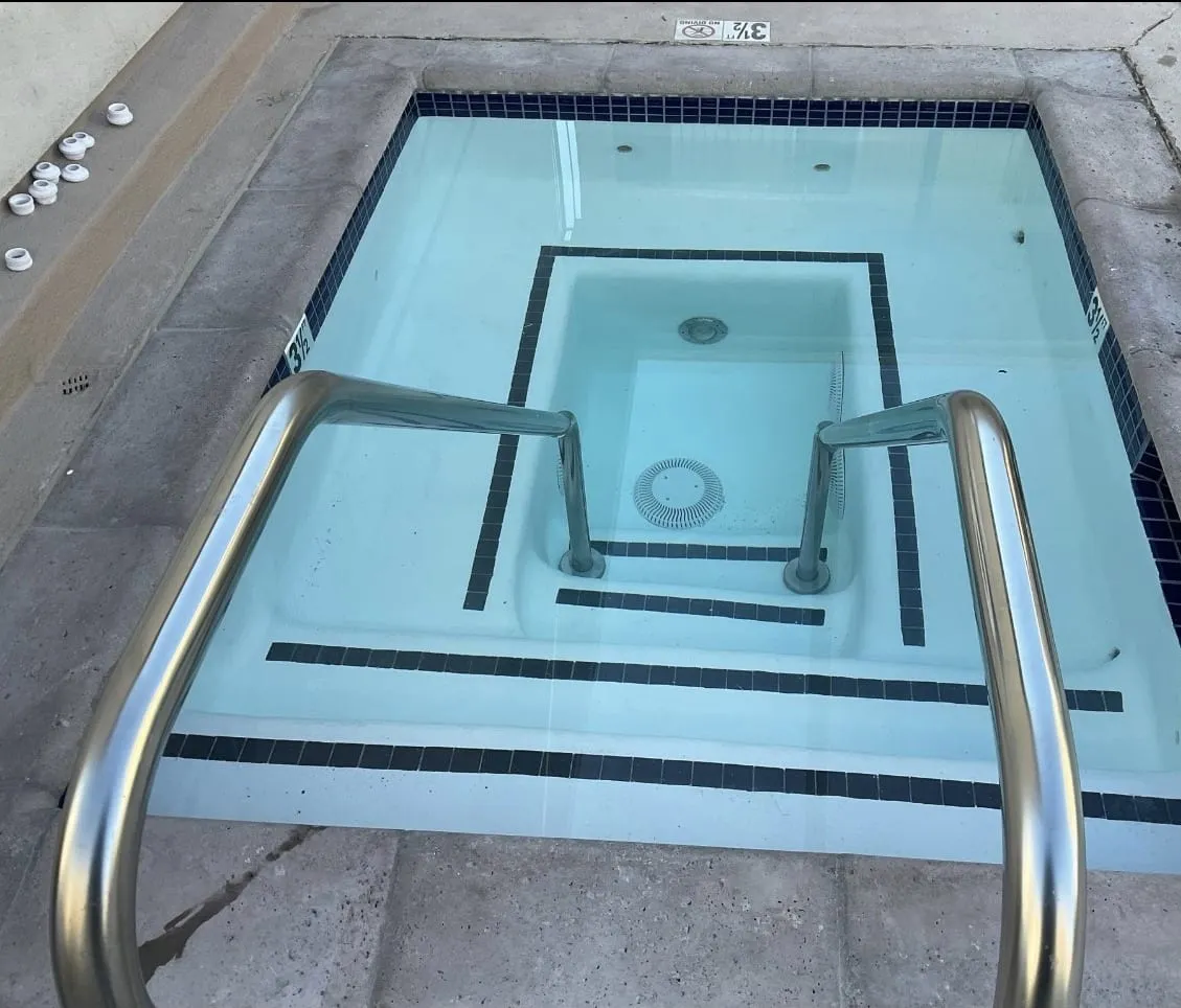 A filled commercial spa with clear water and navy tile trim.